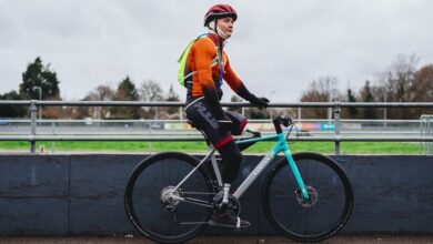 Double amputee Billy Monger sat on his bike in an orange top and helmet