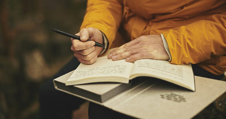 Person writing a story in a book - Image by Pexels from Pixabay