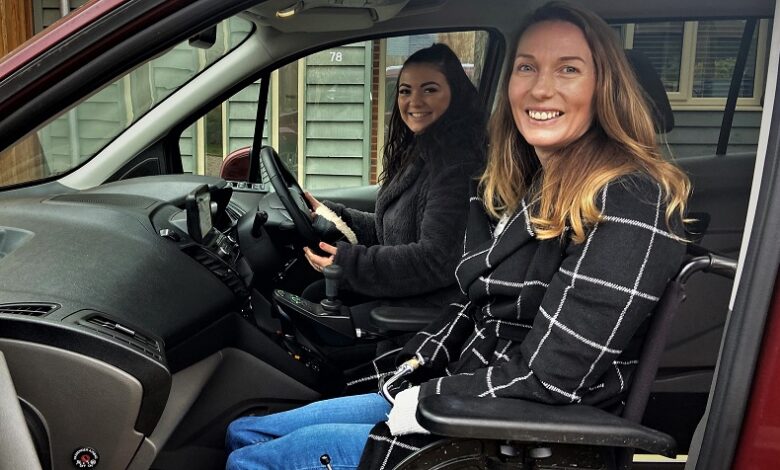 Two woman sat in an adapted car with the wheelchair user as a passenger upfront next to the driver