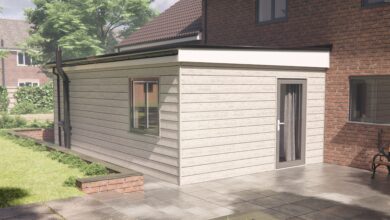 Adapted modular home extension in while clad exterior fitted onto a brick home at the side in the garden