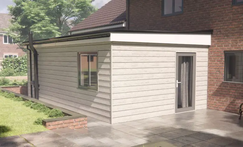 Adapted modular home extension in while clad exterior fitted onto a brick home at the side in the garden