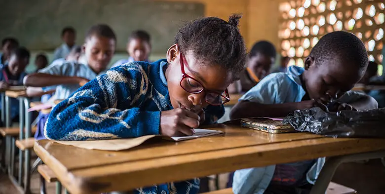 A group of girls are sitting in a classroom in Zambia