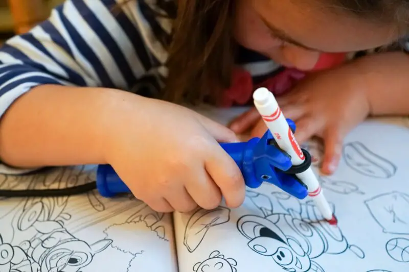 Functionalhand gripping aid being used by a young girl to hold a pen to colour in