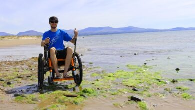 Tim Morgan in his Mountain Trike all-terrain wheelchair on a rocky beach