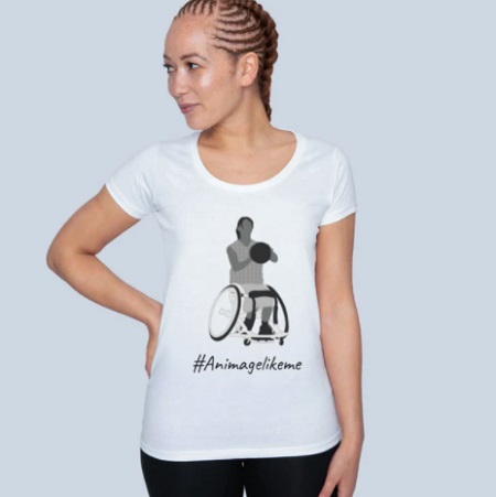 Woman wearing a white T-shirt from Diversity Designs showing a woman in a wheelchair and the words an image like me