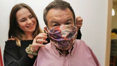 Holly Yendell helping her father Tom put on a patterned face mask