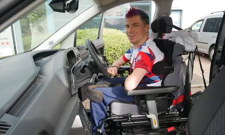 Paralympian David Smith sat in the driver's seat in his wheelchair in the new Sirus VW Caddy Maxi Life 5 wearing a Team GB t-shirt