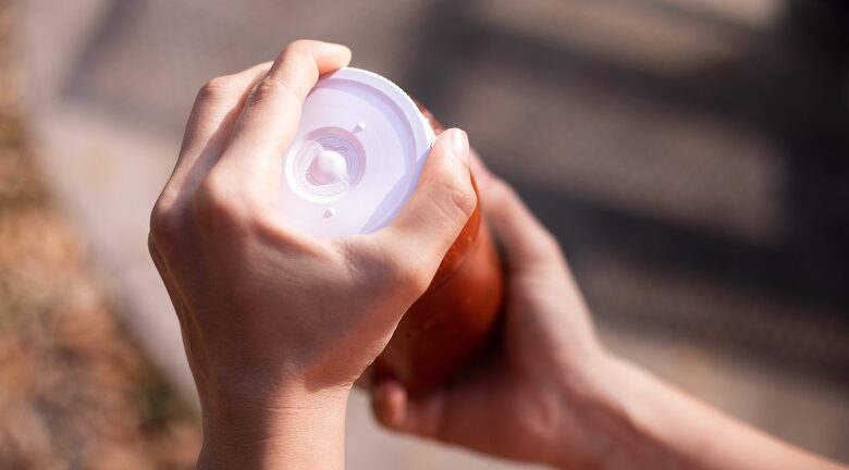 The accessible EEASY lid being screwed off a bottle