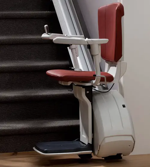 A stairlift from Prime Stairlifts at the bottom of a set of straight stairs