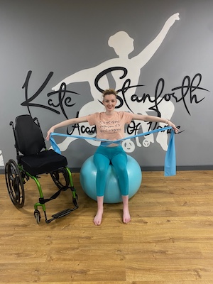 Kate Standforth stood by her wheelchair in the studio