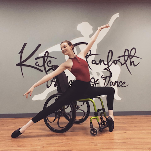 Kate Stanforth doing a dance pose in her wheelchair