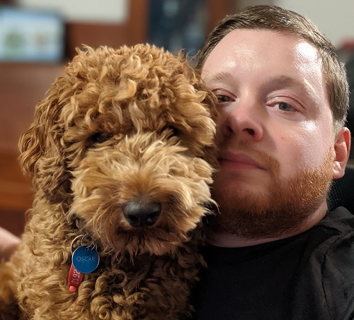 Disabled vlogger Carl Thompson with his red Cavoodle Oscar