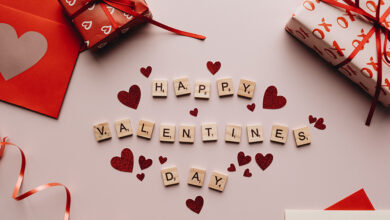 Happy Valentine's Day written in scrabble letters with hearts and gifts in red wrapping paper around them