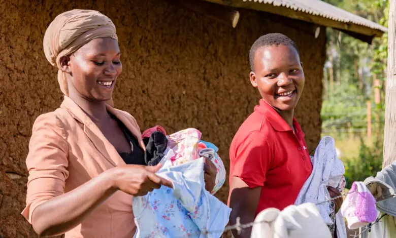 Two black women in Africa carrying washing smiling