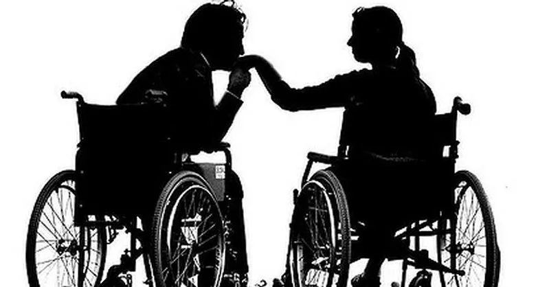 Sillohette-image-of-man-kissing-womans-hand.-They-are-both-in-wheelchairs.jpg
