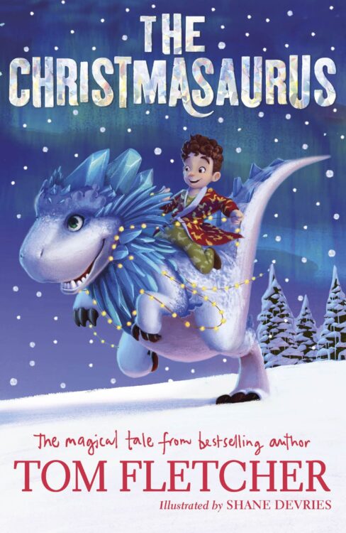 The Christmasaurus book showing a boy riding a blue dinosaur on the snow