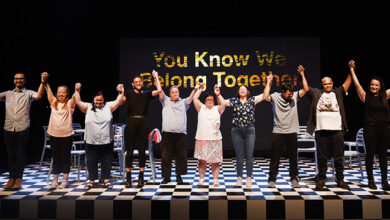 - Cast of We Know We Belong Together on stage about to take a bow. The background is black and there is a black and white chequered floor