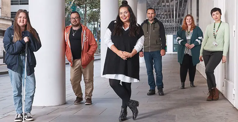 Scarlett Moffatt stood under a building with five young men and women who have Tourette's syndrome