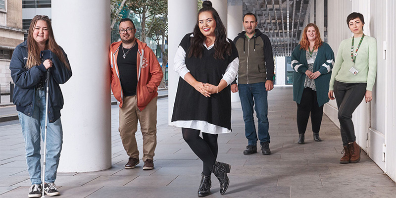 Scarlett Moffatt stood under a building with five young men and women who have Tourette's syndrome
