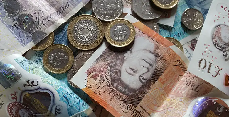 5, 1 and 20 pound notes and 1 and 2 pound coins spread on a table