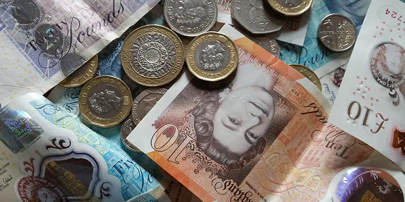 5, 1 and 20 pound notes and 1 and 2 pound coins spread on a table