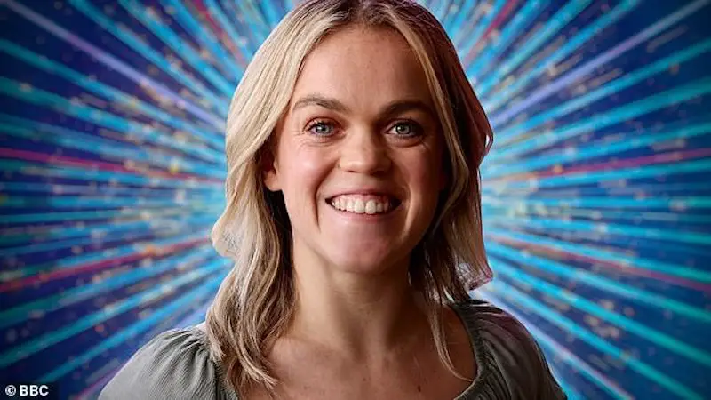 Paralympian Ellie Simmonds on Strictly Come Dancing 2022. She has shoulder length light brown hair and is wearing a beige top, standing in front of a sparkly blue background