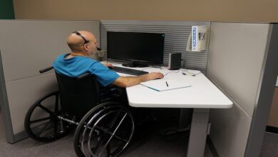 A man in a wheelchair using headphones with his computer