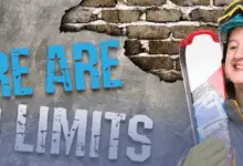 Smiling skier in a helmet and goggles holds skis beside large text on a brick wall that reads: “There Are No Limits.”