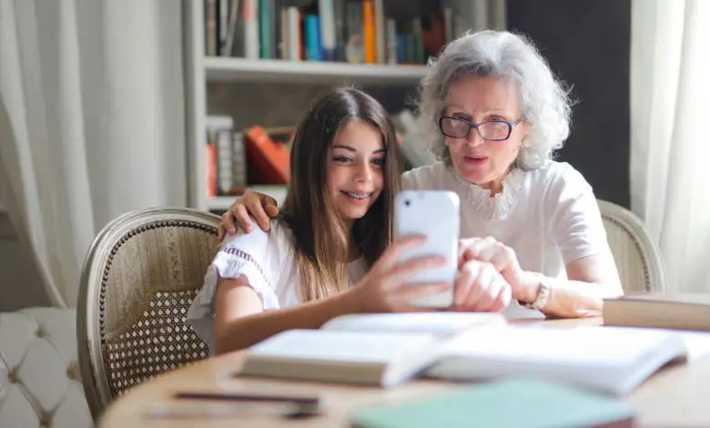 older woman showing something on her phone to younger girl (grand daughter?)