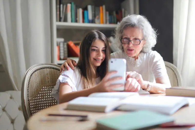 older woman showing something on her phone to younger girl (grand daughter?)
