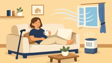 Disabled person relaxing on a sofa, holding a mug, with a cane nearby. An open window and air purifier show fresh air flowing in a calm living room.