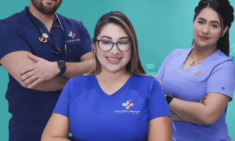 Three healthcare staff in blue and purple scrubs stand in a clinic reception area.