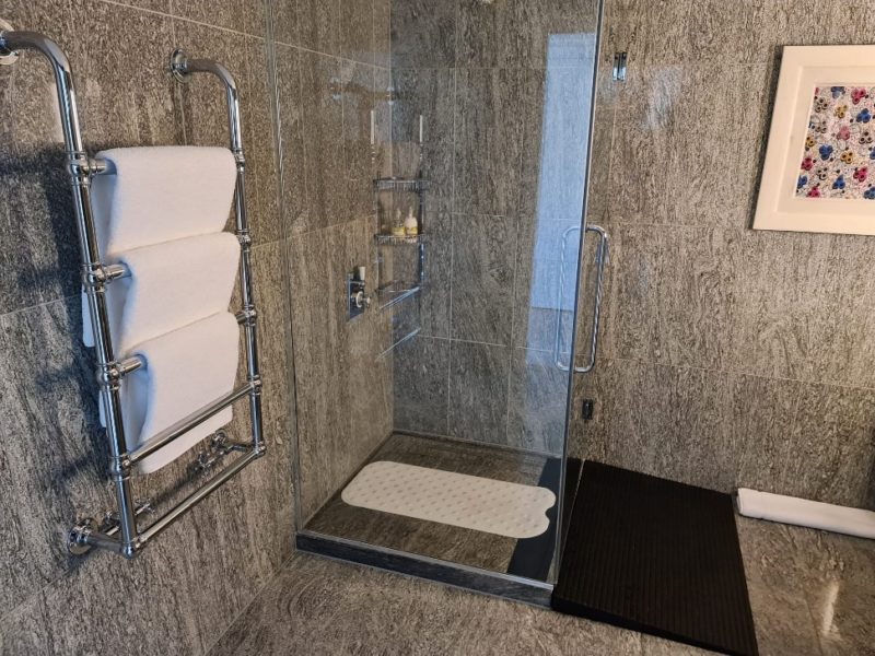 Accessible bathroom at Ham Yard Hotel with a ramp leading into a walk-in shower.