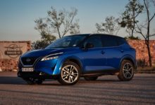 Blue Nissan Qashqai parked outdoors, viewed from the front and side.