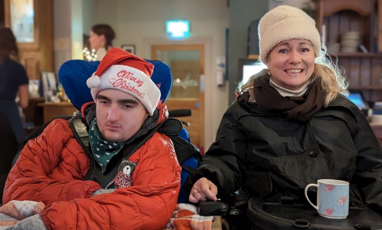 Two wheelchair users seated together, one using specialist supportive seating and the other with a Trabasack lap tray holding a mug.